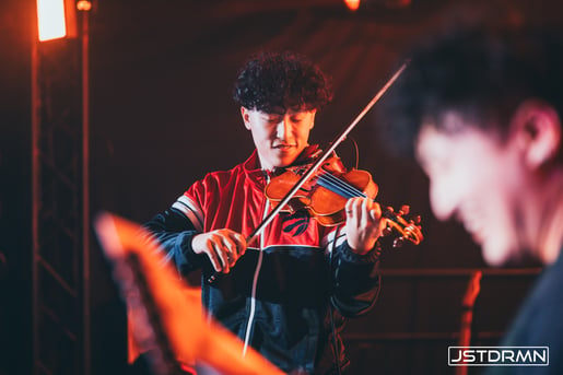 An artist playing the violin, illustrating how traditional instruments can serve as the lead melody in EDM tracks, as discussed in 'Understanding the Core Components of an EDM Song'.